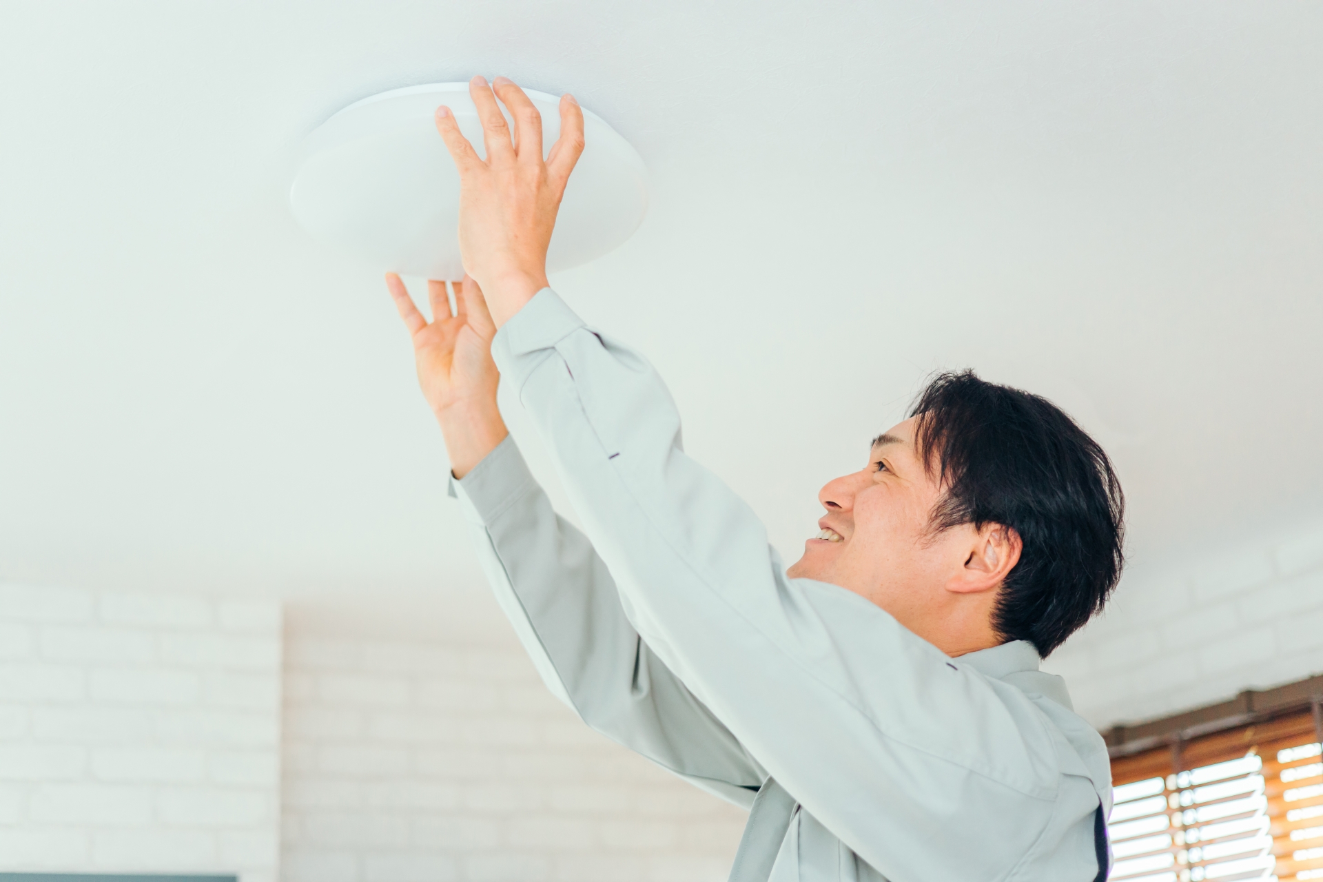 シーリングライトを外す人