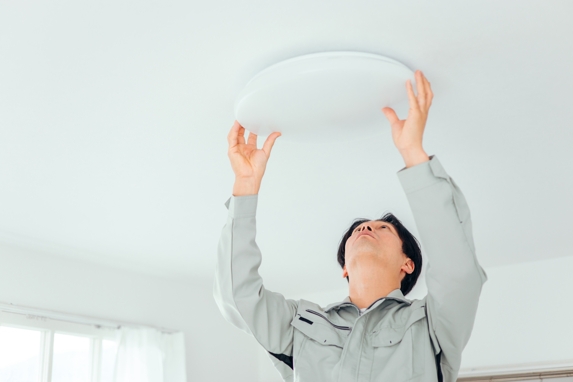 白いシーリングライトと男性