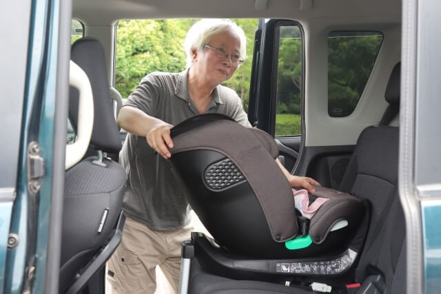 車両からチャイルドシートを外す男性