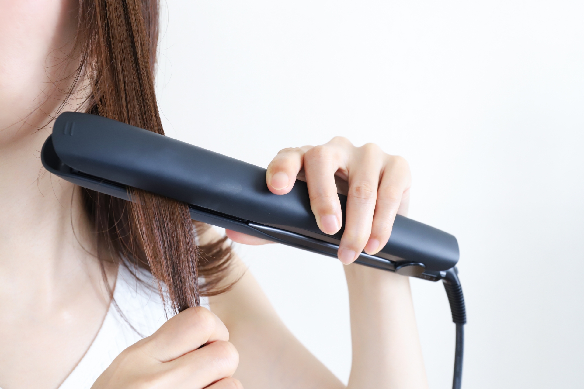 ヘアアイロンを使う女性