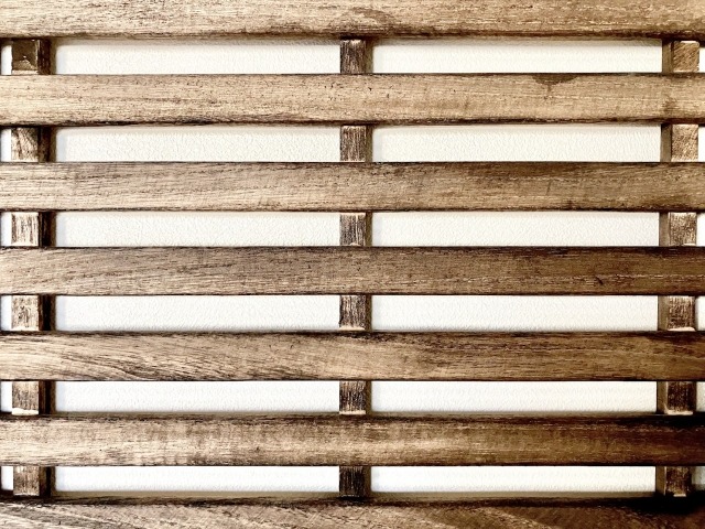 白い壁に立てかけられた古いすのこ