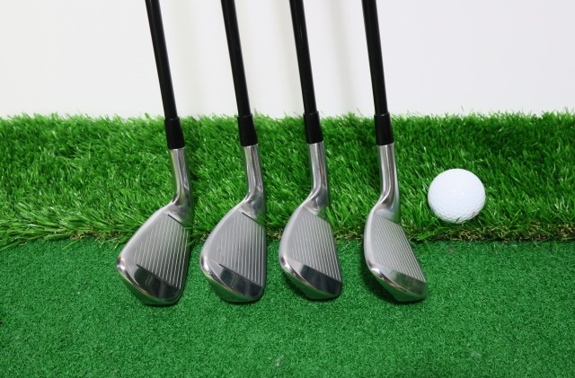 人工芝に並ぶゴルフクラブとボール