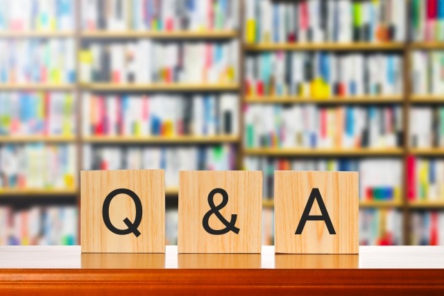 本棚の前に置かれたQ&Aの木製ブロック