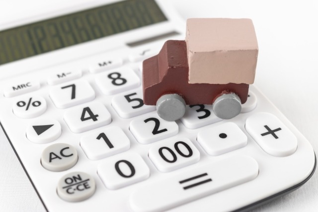 電卓の上に置かれたおもちゃのトラック