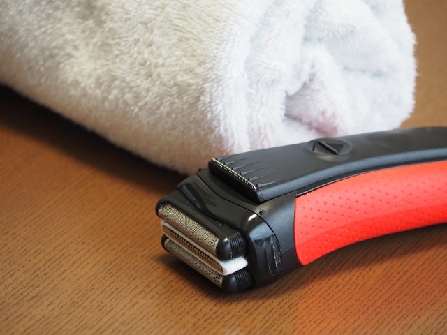 ーブルに置かれたタオルと電動シェーバー