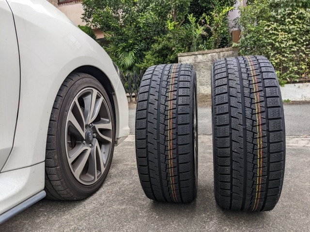 自動車の隣に並べられた2本のタイヤ