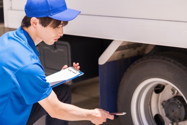 車のタイヤをチェックする男性