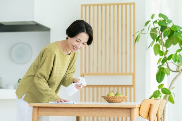 ダイニングテーブルを拭く女性