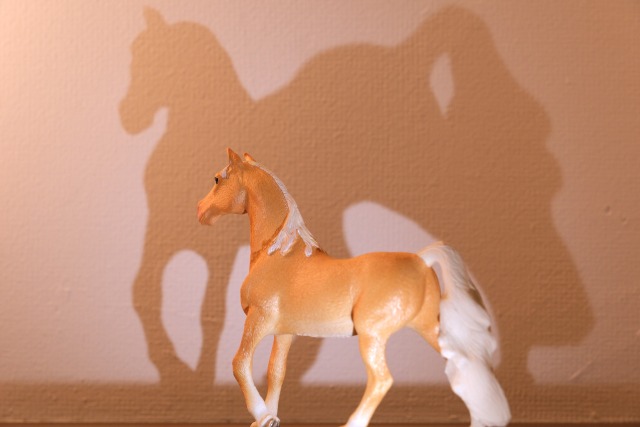 白い壁に置かれている馬のフィギュア