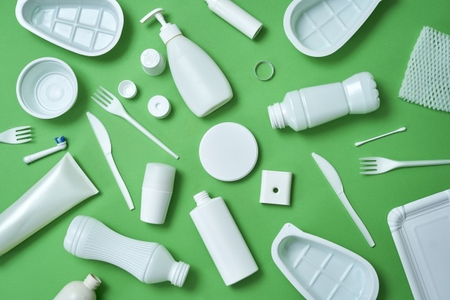 緑色の背景に散乱するプラスチックごみ