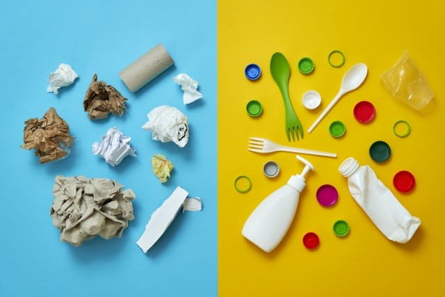 青い背景に紙ごみ、黄色の背景にプラスチックごみが置かれている