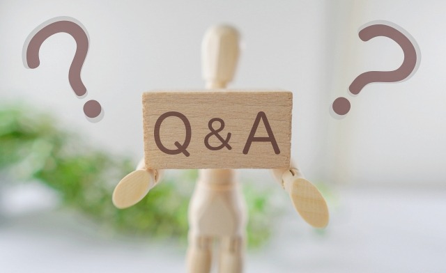 木の人形がQ&Aの木製ブロックを掲げている