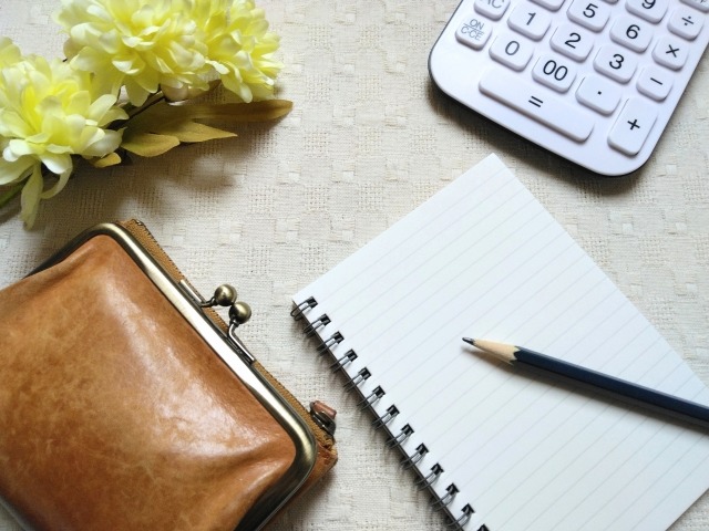テーブルに置かれた電卓とメモ帳
