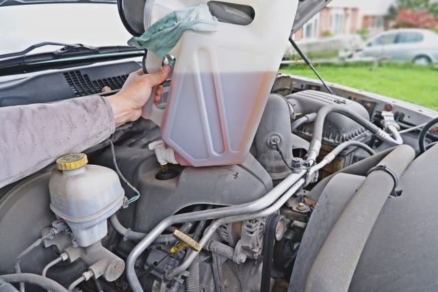 エンジンルームの上で掲げるオイルタンク