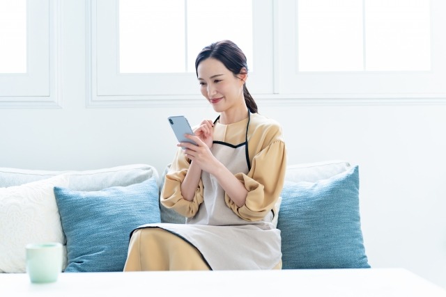 スマホを見て考える女性