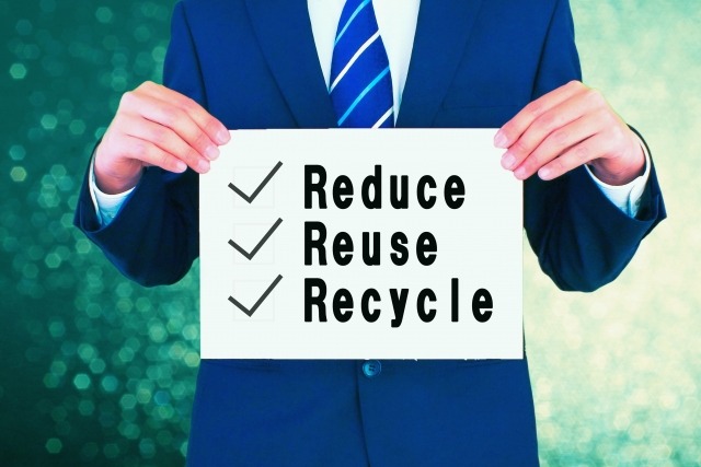 リデュース・リユース・リサイクルが書かれたボードを持つ男性