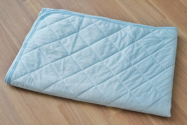 畳んで置かれた水色の接触冷感敷きパッド