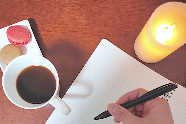 アロマキャンドルで照らしたノートと手元