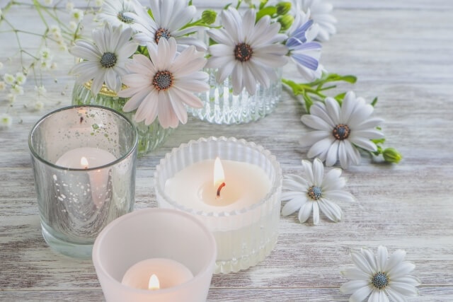 白いテーブルに置かれた花とアロマキャンドル