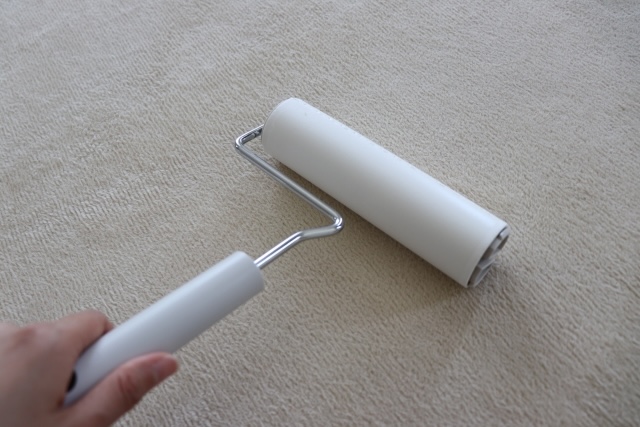 粘着ローラーを掛ける白いカーペット