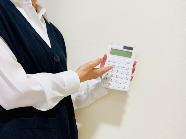 白い電卓を持つ手