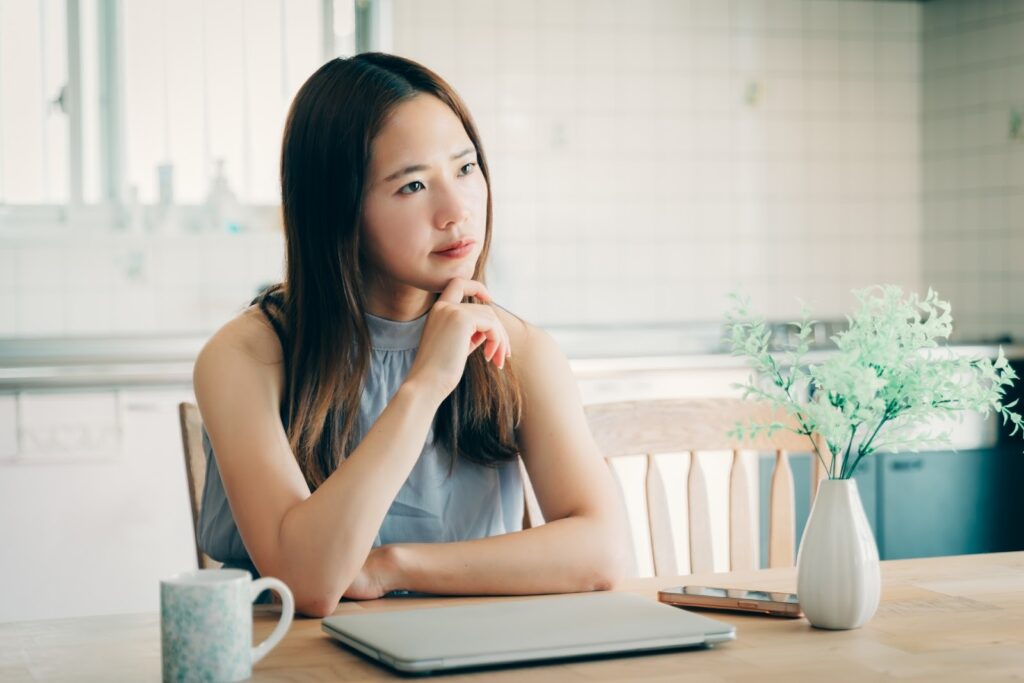 肘をついて考える女性