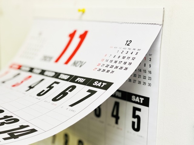 壁掛けカレンダーの11月をめくる様子