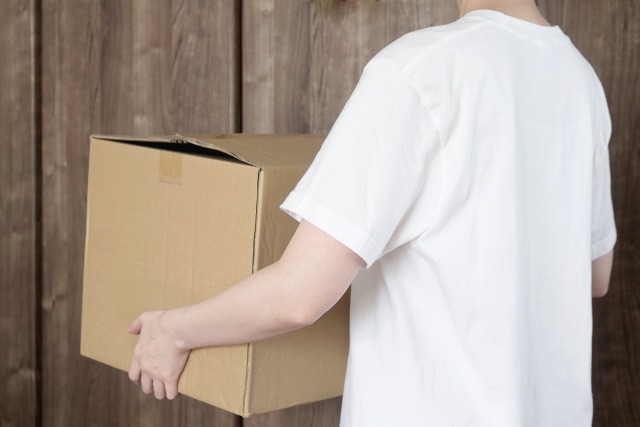 段ボール箱を抱える人