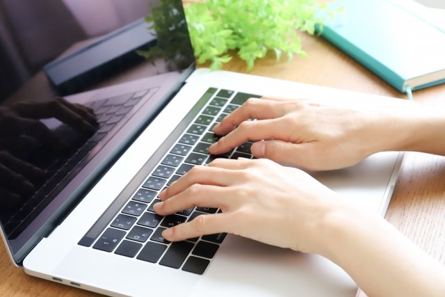 ノートパソコンで作業する手元