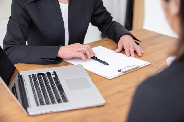 スーツを着た女性が対面で相談する様子