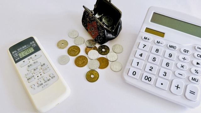 エアコンのリモコンと小銭と電卓