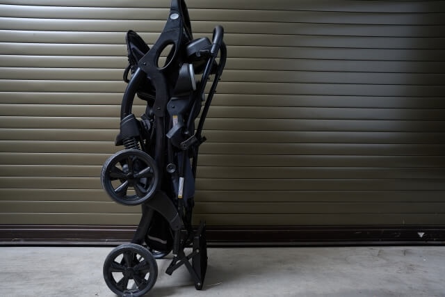 シャッターの前に置かれた畳んだベビーカー