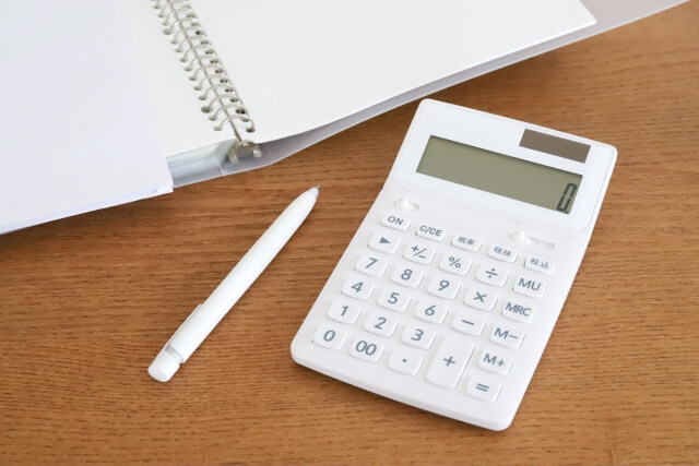 木製テーブルに置かれた白い電卓