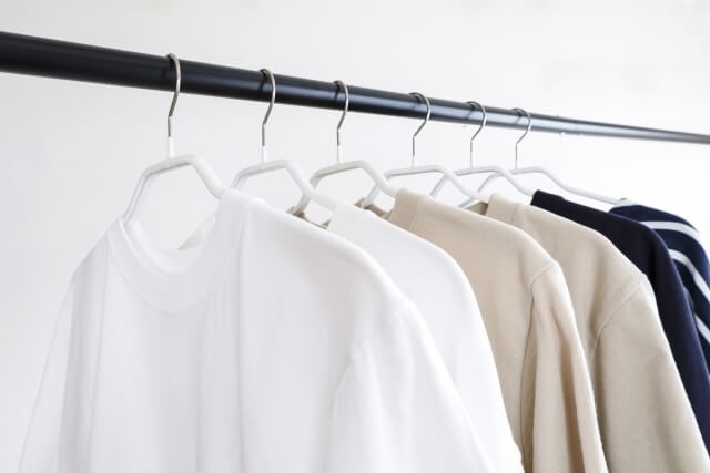 服が掛かった黒いハンガーラック