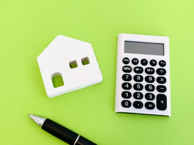 白い家型ブロックと電卓