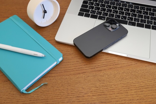 手帳とパソコン・スマホを広げたデスク