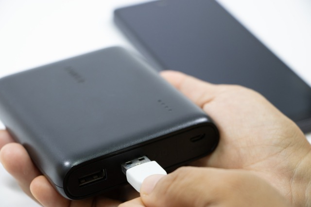黒いモバイルバッテリーに端子を差し込む様子