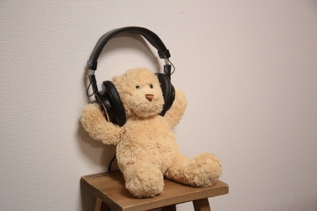 ヘッドホンを装着するくまのぬいぐるみ