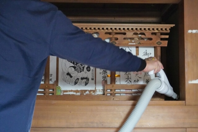 神棚を掃除機で掃除する様子