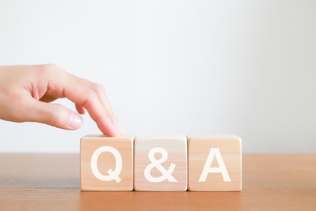 手が添えられたQ&Aの木製ブロック