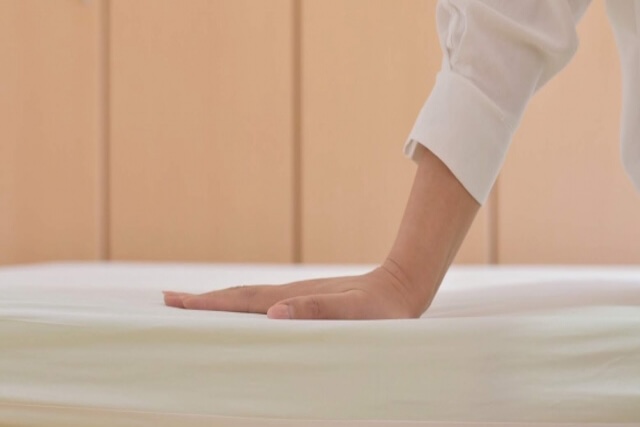 マットレスに手を乗せる様子