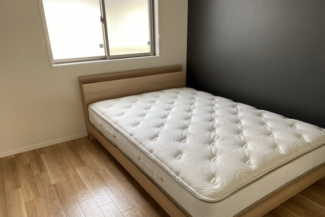 木製ベッドに置かれたマットレス