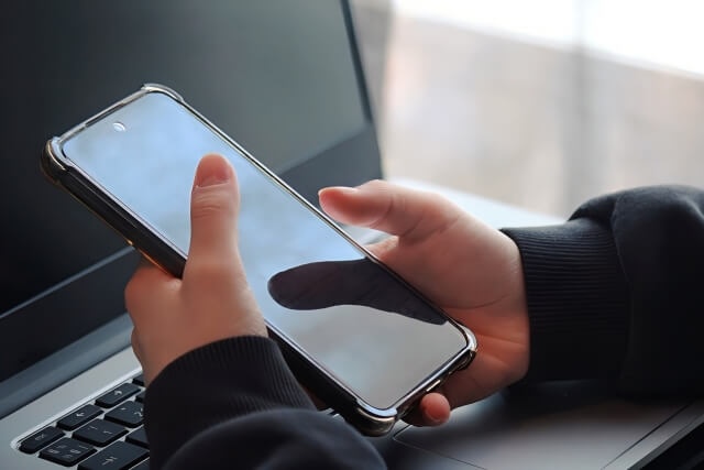 パソコンとスマホを操作する手元の画像