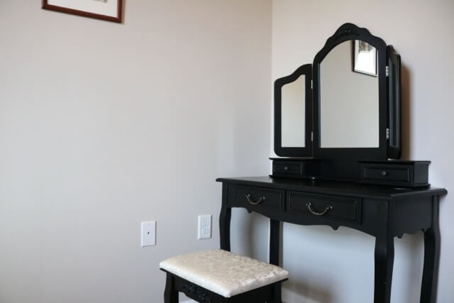 白い壁の前に置かれた古い鏡台
