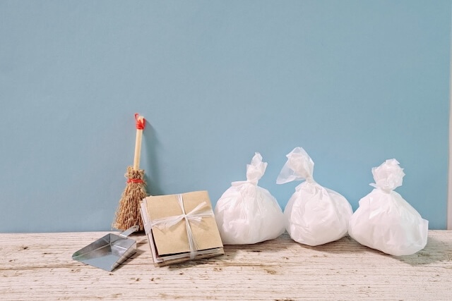 水色の壁の前に置かれたミニチュアのごみ袋