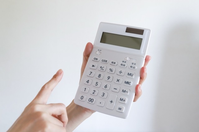 白い電卓と指さす手