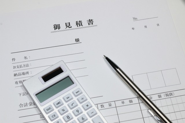 見積書に電卓とペンを広げる様子