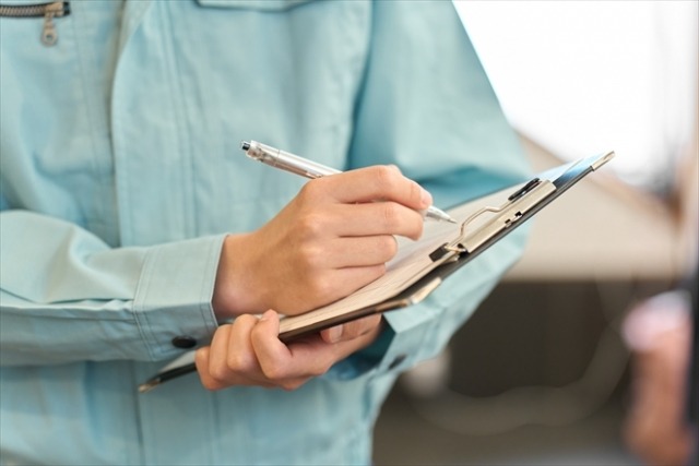 バインダーに文字を書く作業員