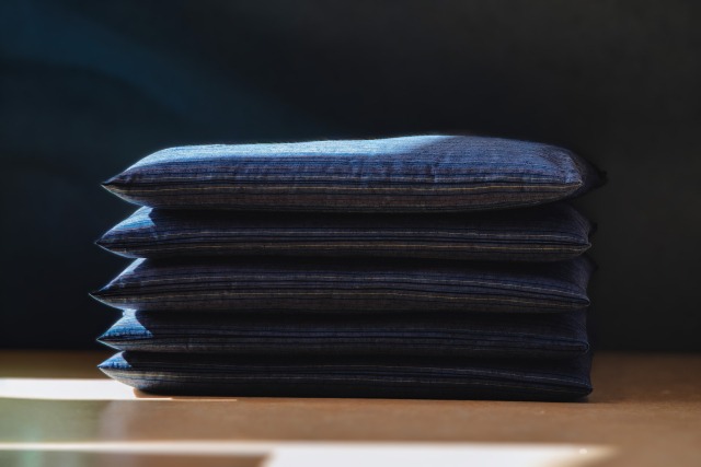 窓際に積まれた5枚の青い座布団