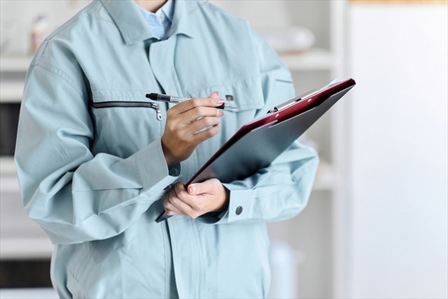 バインダーを片手に調査する作業員の男性